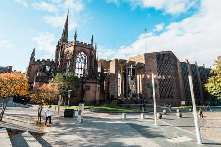 Coventry, England - October 23, 2016: people are walking on the street and passing by the runied Cathedral Church of St Michael in Coventry, Englandのeditorial素材