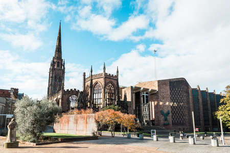 Coventry, England - October 23, 2016: people are walking on the street and passing by the runied Cathedral Church of St Michael in Coventry, Englandのeditorial素材