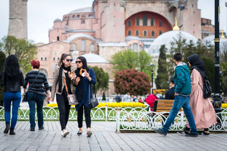 Istanbul, Turkey - April 12, 2017: Ladies are eating turkish bagels in Sultanahmet square near the Hagia Sophia Museum during the Istanbul Tulip festival in April.のeditorial素材