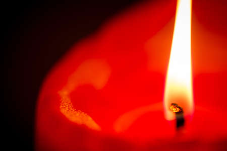 Macro of burning candle isolated on dark backgroundの写真素材