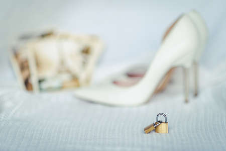 Greeting card of wedding, two locks symbolizing true love and white bridal shoesの写真素材