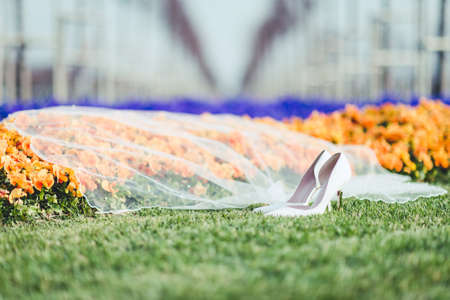 Wedding detaÄ±l photography. White wedding shoes and veil outdoors for Spring wedding.の写真素材