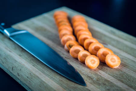 Fresh raw slÄ±ced carrot on the wooden board. Cooking vegetarian mealの写真素材