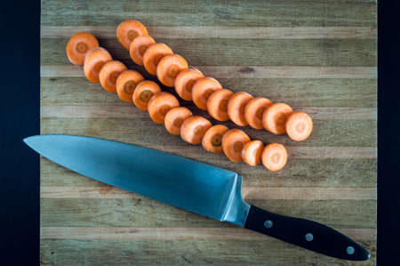 Fresh raw slÄ±ced carrot on the wooden board. Cooking vegetarian mealの写真素材