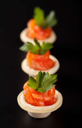 Canape with smoked salmon fish on black background の写真素材
