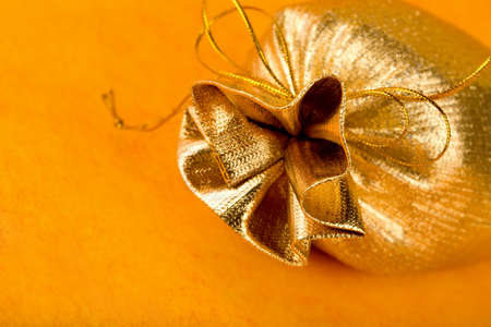 Golden gift sack over orange backgroundの写真素材
