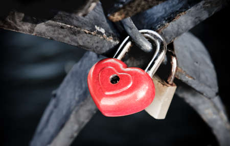 Red heart shaped lock on a fence - symbol of eternal love