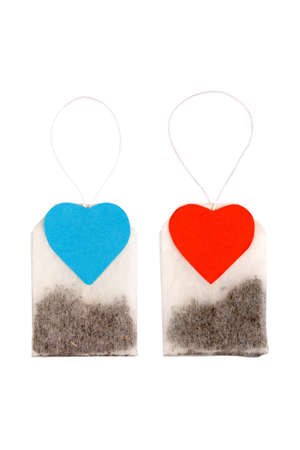 For him and for her. Two tea bags with heart-shaped blue and red labels isolated on whiteの写真素材