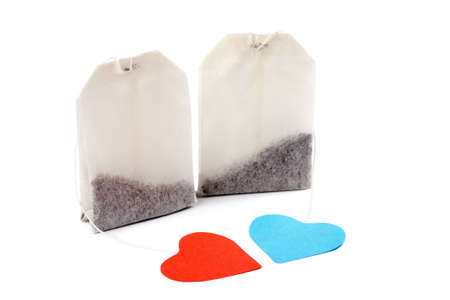Two tea bags with heart-shaped blue and red labels isolated on white. For him and for herの写真素材