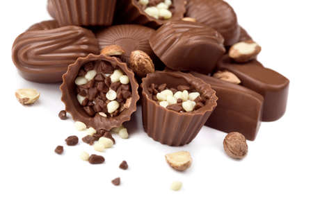 Assorted chocolate candies and nuts isolated on white