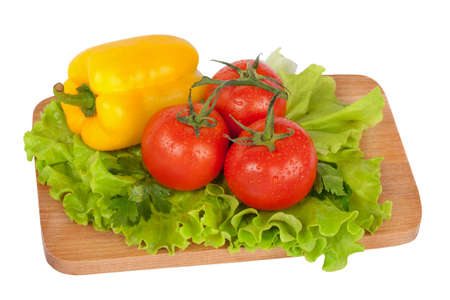 Fresh colorful vegetables on wooden board isolated on whiteの写真素材