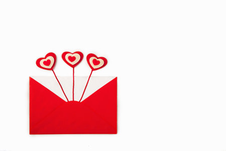 Open red envelope with three red hearts coming out as love letter. Valentines Day concept. Top view,...
