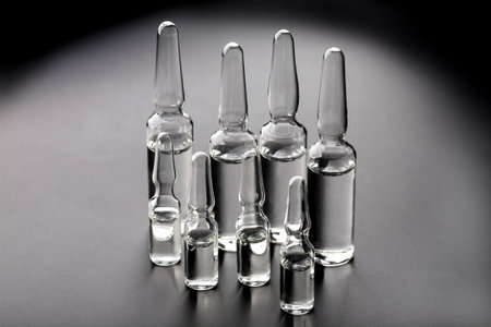 New vaccine in ampules on black background. Two different ampules size.の写真素材