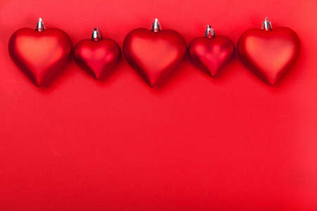 Valentines Day greeting card with red hearts on red background. Top view with empty space for your text. Flat lay, copy spaceの写真素材