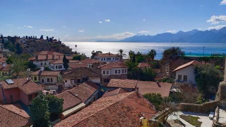 Top view of pivate houses with red tiled roofs and The Mediterranean Sea and mountains in the city of Antalyaの写真素材