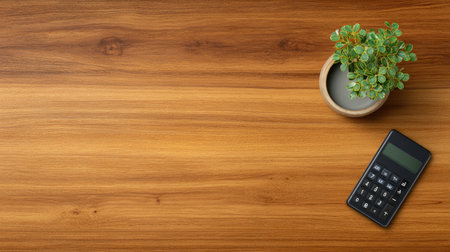 A serene workspace featuring a wooden desk with a simple calculator and a potted plant, ideal for promoting focus and productivity in a minimalist setting.の素材