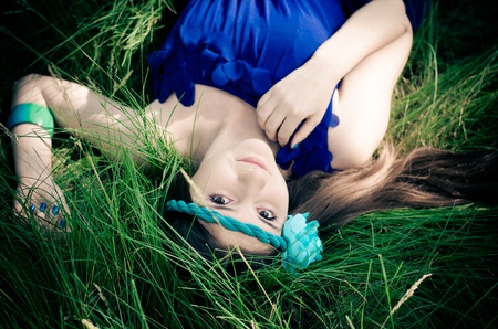 Beauty in blue dress lying in the grass の写真素材