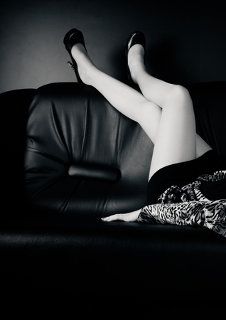 Woman with beautiful legs sitting on sofa.の写真素材