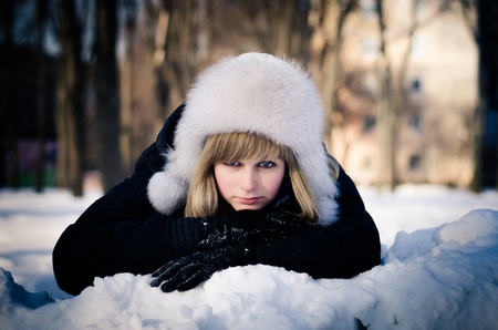 Pretty blonde girl on the sonw in a park. Romantic portraitの写真素材