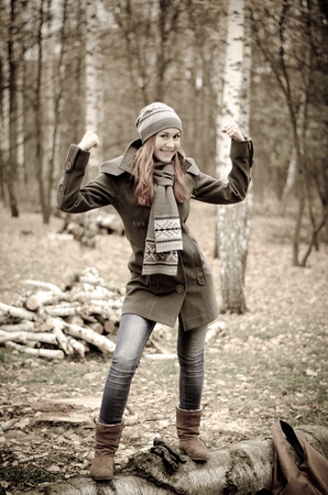Red haired girl smiling in an autumn parkの写真素材