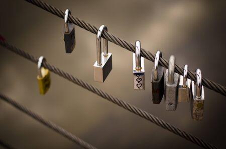 Line of padlocks on a metal ropeの写真素材