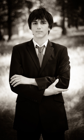 Sepia image of a formal dressed young man with his hands crossed on his chest の写真素材