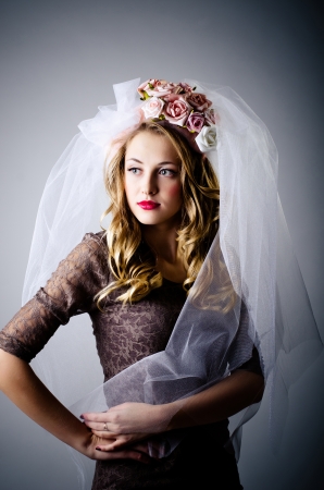 Beautiful young girl in white veil  Grey studio backgroundの写真素材