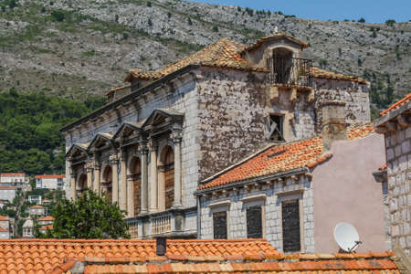 old stone building with a tiled roof and boarded up windows in Dubrovnik. Croatiaの写真素材
