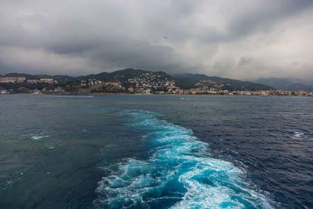 wake in blue water leaving port of Savona, Italyの写真素材