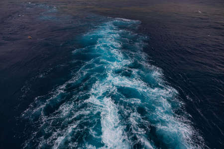 wake in blue water leaving port of Savona, Italyの写真素材
