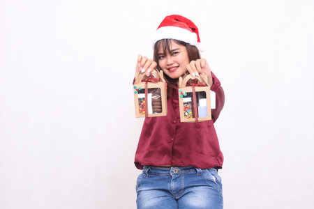 Beautiful young Southeast Asian woman smiling hands forward carrying 2 boxes of hamper gifts at...