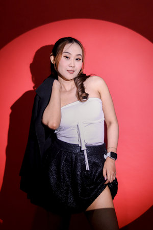 Beauty young Asian woman sexy elegant office wear black formal suit holding jacket up and skirt with...