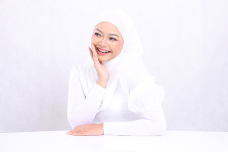 closeup portrait of cheerful young girl asia skin care candid right hand on right cheek with bright, glowing and smooth skin tone. studio on isolated white background for advertising concept. beautyの写真素材