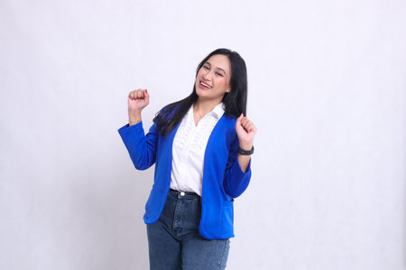 gesture of beautiful young office woman wearing a formal blue suit standing cheerfully with both hands clasped up, a sign of success, success, perfection. for company , beauty, business, financeの写真素材