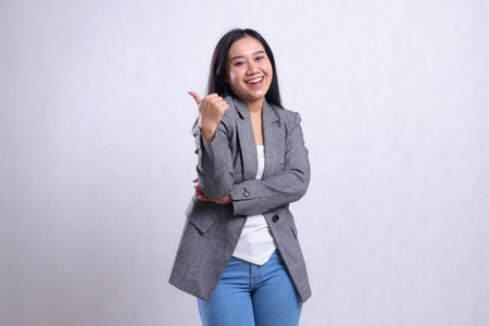 expression of beautiful young woman indonesia happy hug thumbs up sign nice cool wearing grey suit...