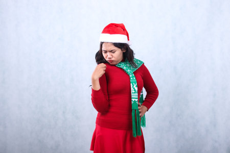 Asian woman expression wearing red sweater party wear with Santa hat and scarf celebrating christmas and new year, isolated on white backgroundの写真素材
