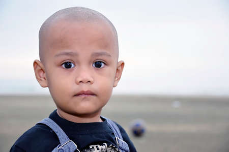 A bold asian boy at the beachの写真素材