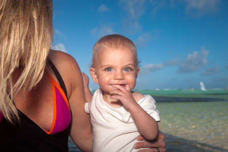 Adorable blond blue eyed boy and mother along Caribbean bayの写真素材