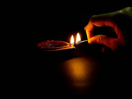 Big oil lamp with hand take a fired joss stick and buddha background.の写真素材