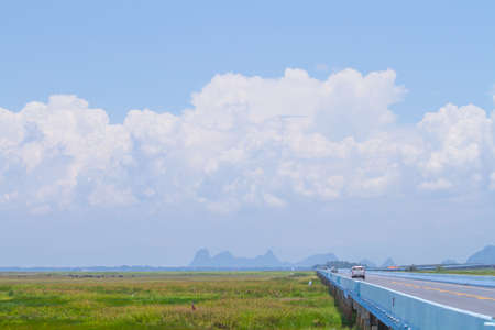 Road bridge across the lake and blue skyの写真素材