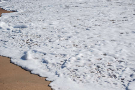 Foam wave of the sea on the sand beach, in Barbate, Cadiz, Spainの写真素材