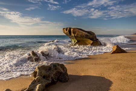 Waves crashing on huge rock on a beach in Cadiz, Spain