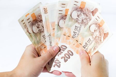 Close up of female hand holding czech banknotes isolated on white background