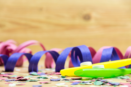 confetti, streamers and party whistle on wood backgroundの写真素材