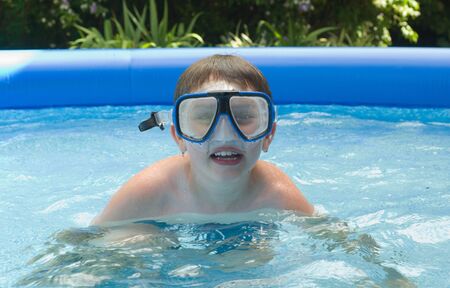 Boy in garden pool with mask