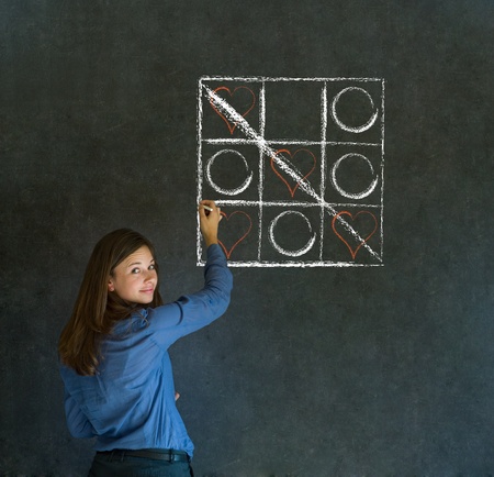 Businesswoman, student or teacher tic tac toe love valentine concpet on blackboard backgroundの写真素材