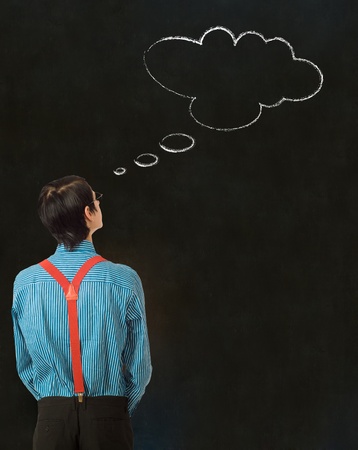 Nerd geek businessman student teacher with thought thinking chalk cloud on blackboard backgroundの写真素材