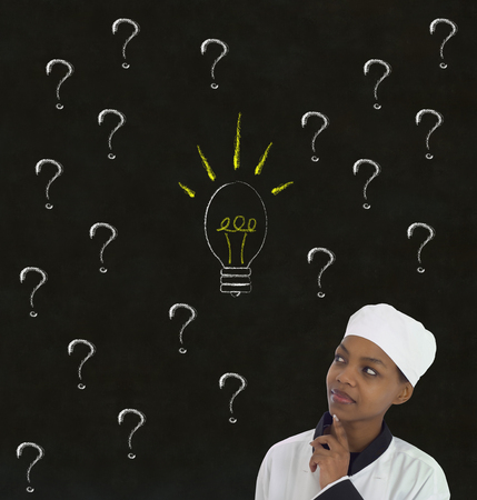 African American Chef with chalk question ideas on blackboard backgroundの写真素材