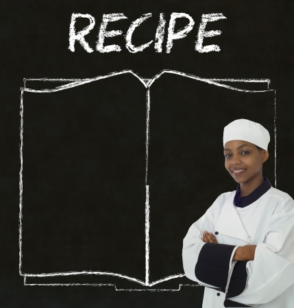 Chef with recipe book on chalk blackboard menu writing backgroundの写真素材