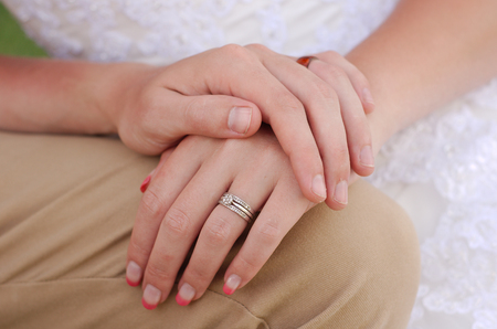 Bride and groom holding hands with marriage wedding ringの写真素材